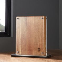 a wooden box sitting on top of a hard wood floor next to a framed window