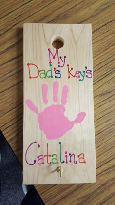 a wooden sign that says, my dad's keys catalina with handprints on it