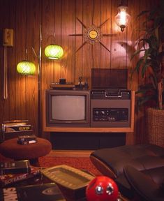 a living room with a tv, couch and chair in front of a wooden wall