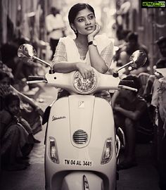 a woman sitting on the back of a scooter