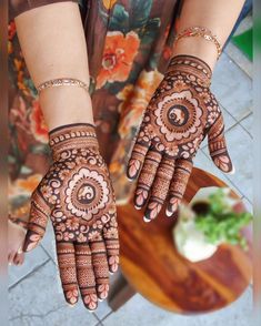 a woman's hands with hennap on it and flowers in the background