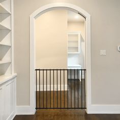 an open door leading to a room with white walls and wood flooring on the other side