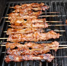 several skewered meats are being cooked on the grill