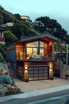 a large house on the side of a hill with stairs leading up to it's second story