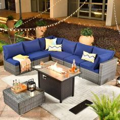 an outdoor living room with blue couches and lights on the side walk in front of it