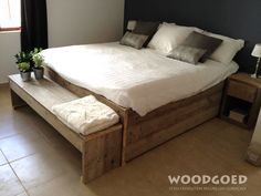 a large bed sitting in the middle of a bedroom next to a table with two vases on it