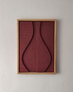 an abstract painting on the wall in a wooden frame with red paint and wood trim