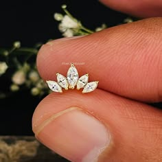 a close up of a person's hand holding a ring with three diamonds on it