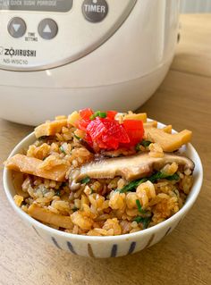 a bowl filled with rice and vegetables next to an electric pressure cooker