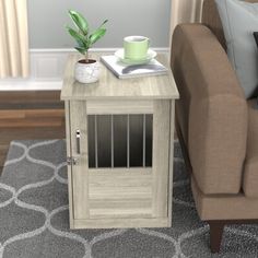 a living room with a couch, chair and small dog crate on the carpeted floor