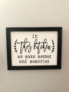 a framed sign that says in this kitchen we make messes and memories on the wall