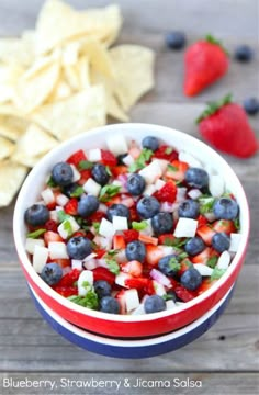 blueberries, strawberries and other fruit are in two bowls