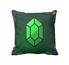 a green pillow with an image of a diamond on the front and side, surrounded by multicolored flowers