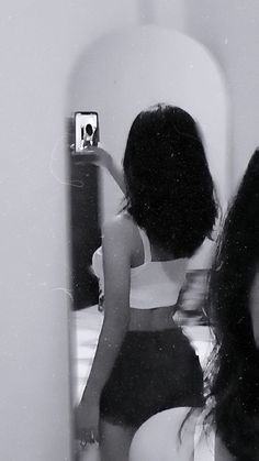 a woman taking a selfie in front of a mirror