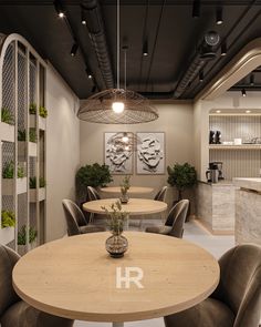 a table and chairs in a room with plants on the wall