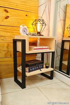 a table with a clock and some books on it next to a mirror in a room