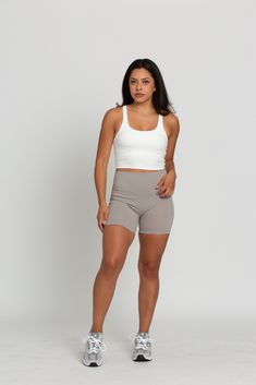 Our White Racerback Crop Tank features a slight cropped fit and racerback style that is the perfect go-to athletic top. It is complete with sweat-wicking material and a double layer, built-in-removable padded bra. 75% Nylon, 25% Spandex Built in / Removable Padding Model Details: Modeled in size: Small, Small Model Waist: 26, 30 Model Bust: 33, 34 Model Height: 5'3, 5'6 Tennis Skirts, Athletic Top, Padded Bra, Yoga Tops, V Cuts, Crop Tank, Model Height, Bra Tops, Double Layer