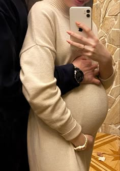 a pregnant woman taking a selfie with her cell phone