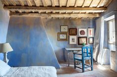 a bed room with a neatly made bed next to a table and two chairs in front of a window