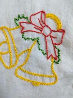 an embroidered bell with a bow on it