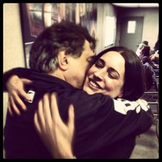 a man and woman hugging each other in an airport