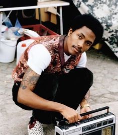 a man kneeling down next to an old radio