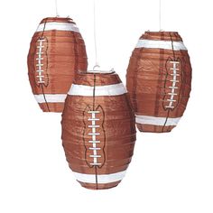 three brown paper footballs hanging from strings