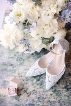 the bride's wedding shoes are next to her bouquet