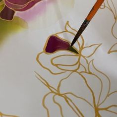 a close up of a flower with a paintbrush in it's mouth and some flowers on the background