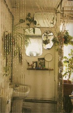 the bathroom is decorated with plants and mirrors