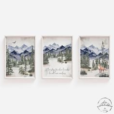 three framed pictures hanging on the wall in front of a white wall with trees and mountains