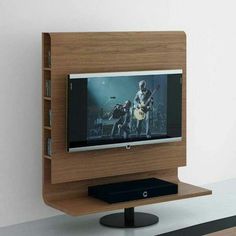 a flat screen tv sitting on top of a wooden shelf