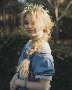 a woman with long blonde hair wearing a blue dress and holding a white frisbee