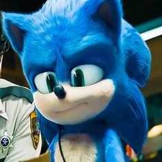 a man in uniform standing next to a blue and white sonic the hedge mascot with big eyes