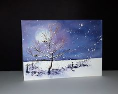 a card with a painting of a tree in the snow