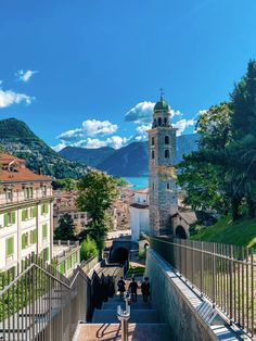 stairs leading up to a tower with a clock on it's side and mountains in the background