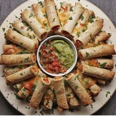 a white plate topped with tortillas covered in guacamole and salsa