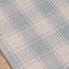 a blue and white checkered rug on top of a wooden floor