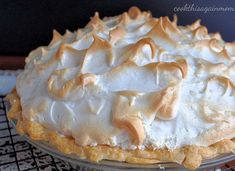 a pie with white frosting on top sitting on a cooling rack