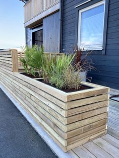 a wooden planter on the side of a building