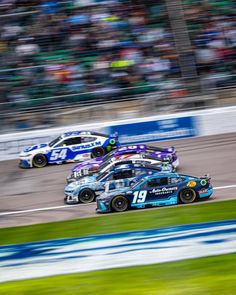 two cars racing on a race track in front of a crowd