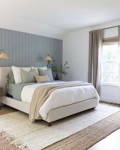 a bed room with a neatly made bed next to a window