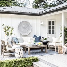 an outdoor living area with white furniture and plants