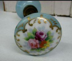 a blue and white vase sitting on top of a table next to a door knob