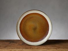 a brown and white bowl sitting on top of a wooden table