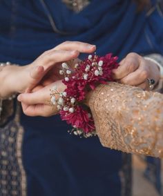 two people holding flowers in their hands while another person holds the other hand out to them