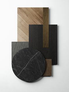 an assortment of wood and marble pieces on a white surface, including a black circle