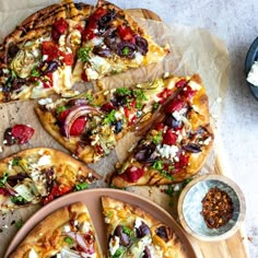 several different types of pizza on wooden platters