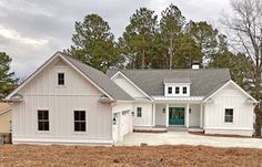 a large white house sitting in the middle of a forest