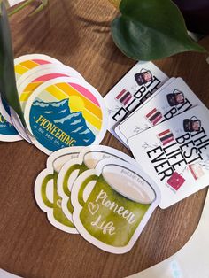 some stickers are sitting on top of a table next to a potted plant